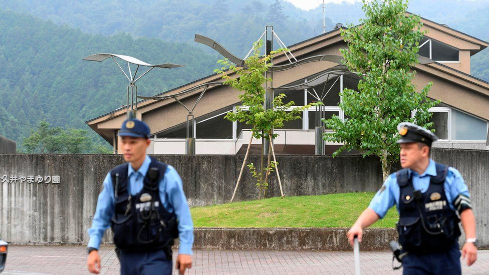 Police officers stand in front of the Tsukui Yamayuri Garden facility for disabled people in Sagamihara, Japan