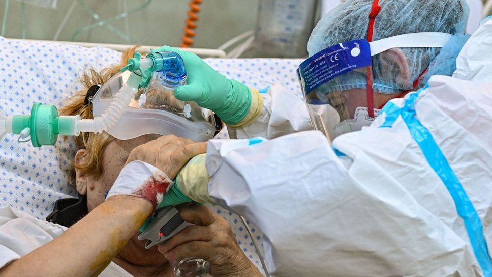 A Covid-19 patient is helped to drink water inside the intensive care unit of the "Pneumophysiology Institute Prof Dr Marius Nasta" in Bucharest, on October 7, 2021