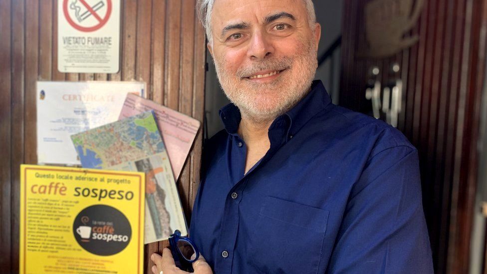 Bar owner Pino de Stasio with a "caffe sospeso" poster