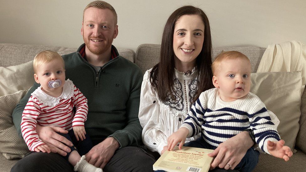 Bethan Dyke, her husband Craig and their twins on a settee a home