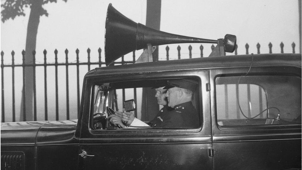 22nd September 1936: Two police officers patrol the misty streets of London in a new loudspeaker van, providing tips on road safety to drivers and pedestrians. (Photo by Ward/Fox Photos/Getty Images)