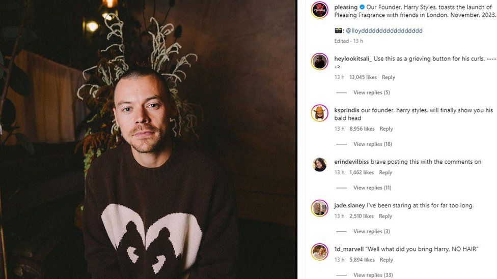 n Instagram post of Harry Styles, a 29-year-old white man, with a newly shaved head. Harry wears a brown jumper with a heart on it and is pictured inside a dark interior in front of a plant. Pleasing's caption is "Our Founder, Harry Styles, toasts the launch of Pleasing Fragrance with friends in London. November, 2023" and below are comments from disappointed fans