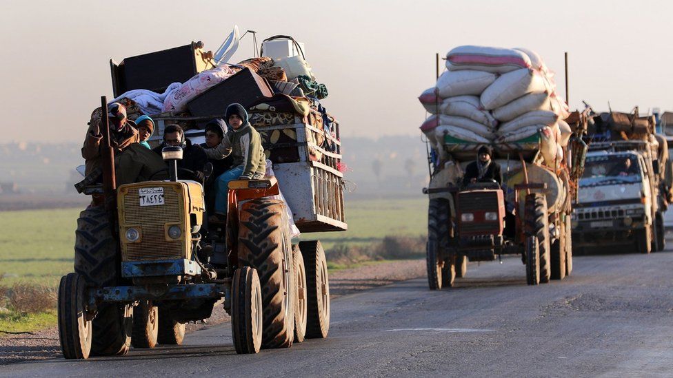 Displaced Syrians travel along a road near the rebel-held town of Saraqeb in Idlib province (7 January 2018)