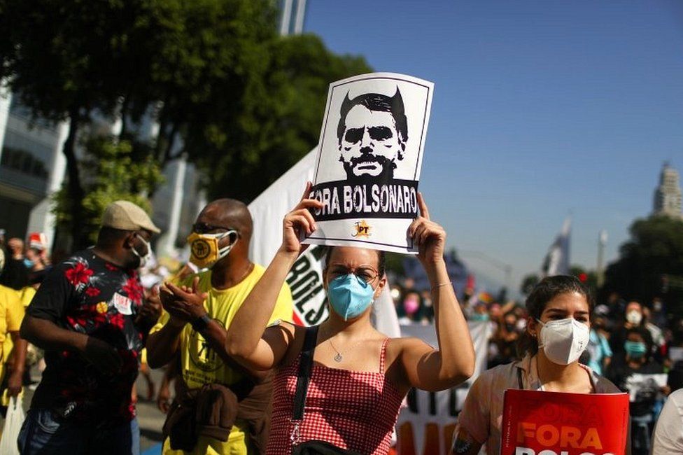 Человек держит табличку с надписью «Болсонару вон» во время акции протеста с призывом к импичменту президента Бразилии Жаира Болсонару в Рио-де-Жанейро, Бразилия, 3 июля 2021 года