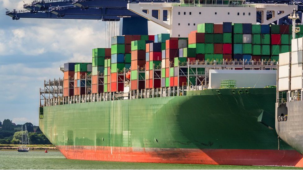Container ship under loading operation with blue gantry cranes in the port of Felixstowe