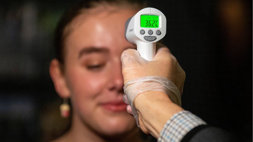 A woman has her temperature checked during coronavirus lockdown