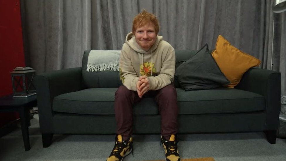 Ed Sheeran sitting on a sofa