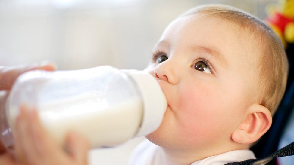 Baby drinking. Nine month old boy drinking a bottle of milk. feeding a baby.