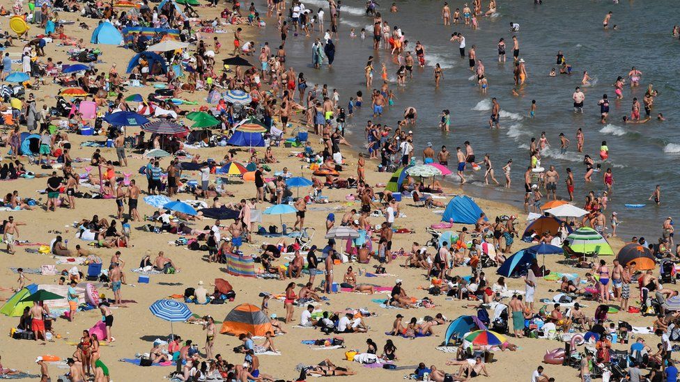 People are seen on the beach in Bournemouth as they enjoy the hot weather, following the outbreak of the coronavirus disease (COVID-19), Bournemouth,