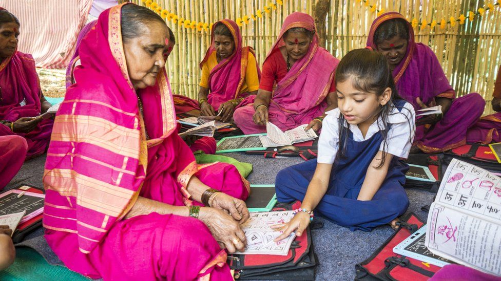 Ramabhai Ganpat learning from little girl in school uniform