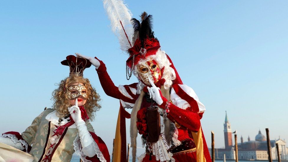 Two masked revellers pose in Venice's Riva degli Schiavoni