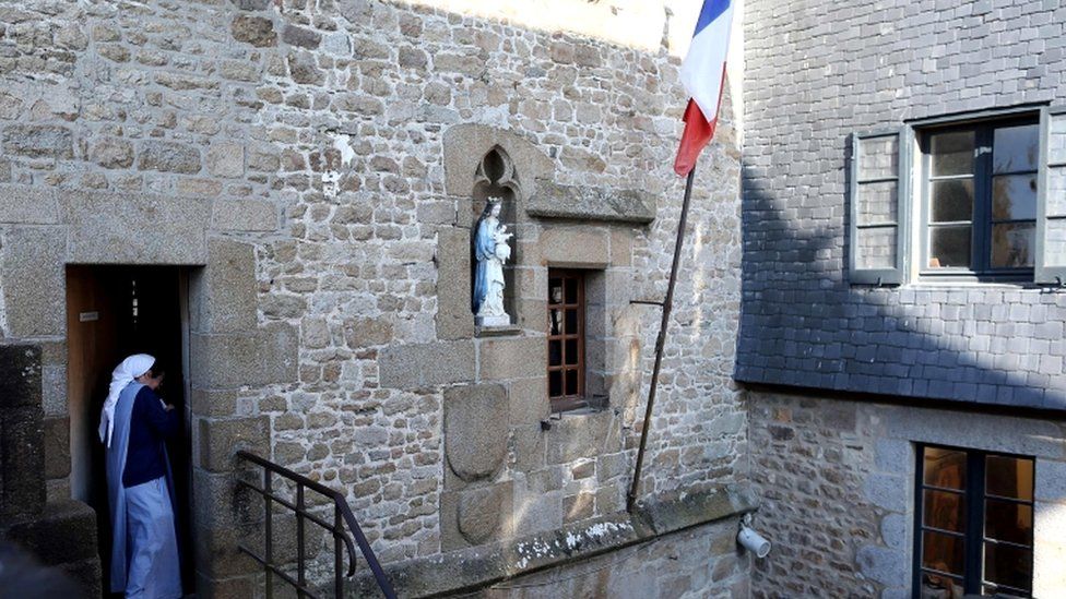 A nun of the Monastic of the Fraternities of Jerusalem leaves a polling station in Le Mont-Saint-Michel