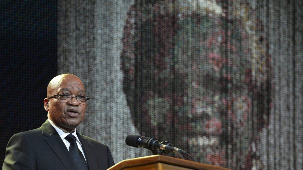 South Africa's Jacob Zuma speaking in front of an image of Nelson Mandela