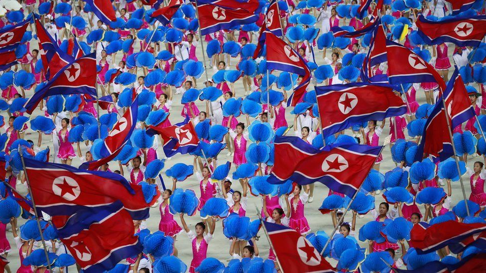 Dancers waving North Korean flags