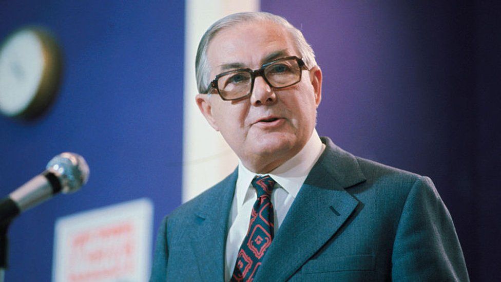 James Callaghan standing next to a microphone
