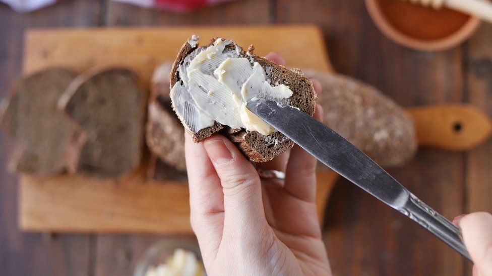 Stock photo of butter being spread on bread