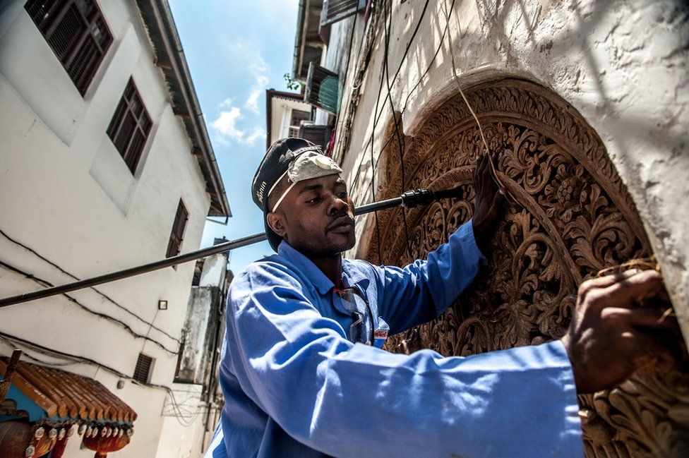 A traditional Zanzibari round-top door is repaired