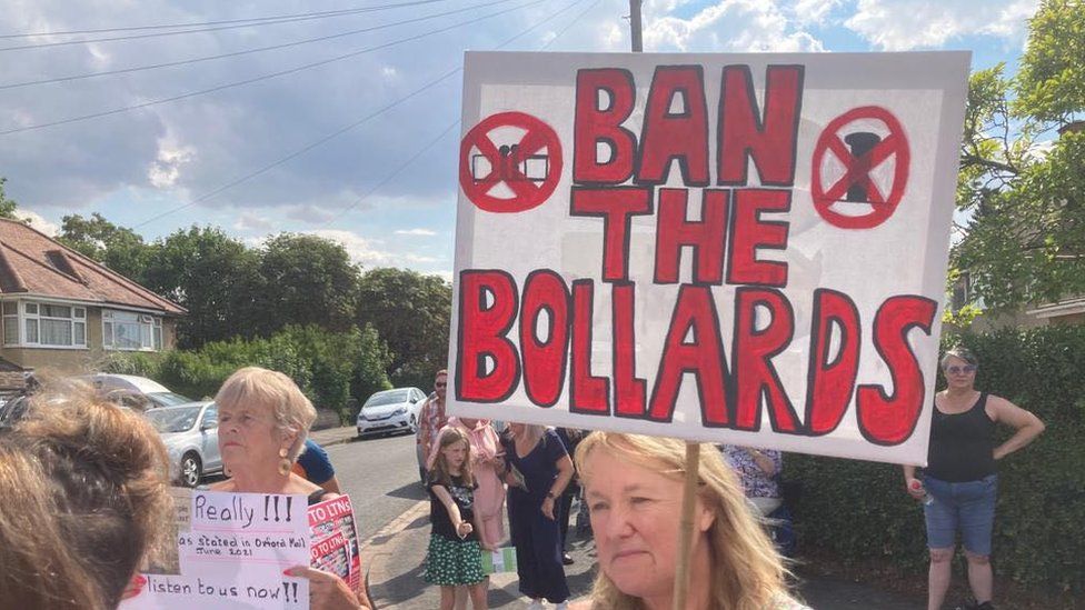 protester with a banner saying 'ban the bollard'