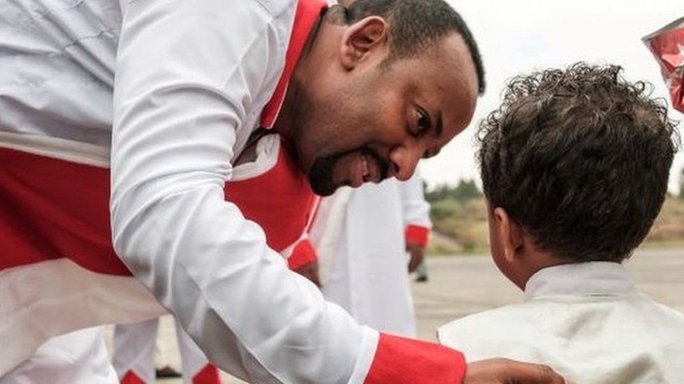 Ethiopia's Prime Minister Abiy Ahmed (C) greets a child as he arrives to welcome Eritrea's President at the airport in Gondar, nothern Ethiopia, on November 9, 2018