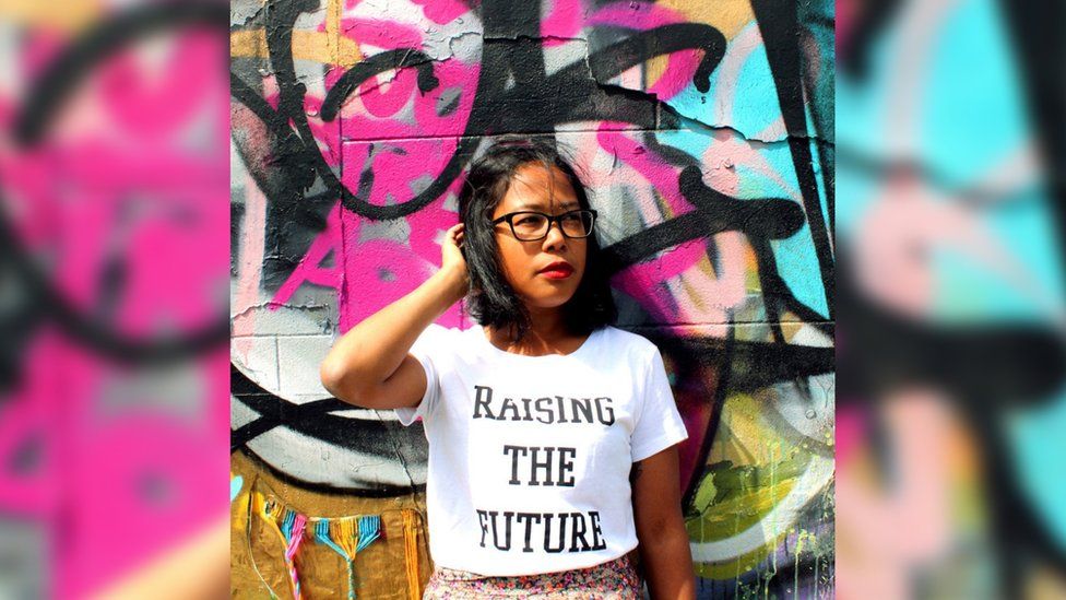 A model wearing the t-shirt emblazoned with 'Raising the future'