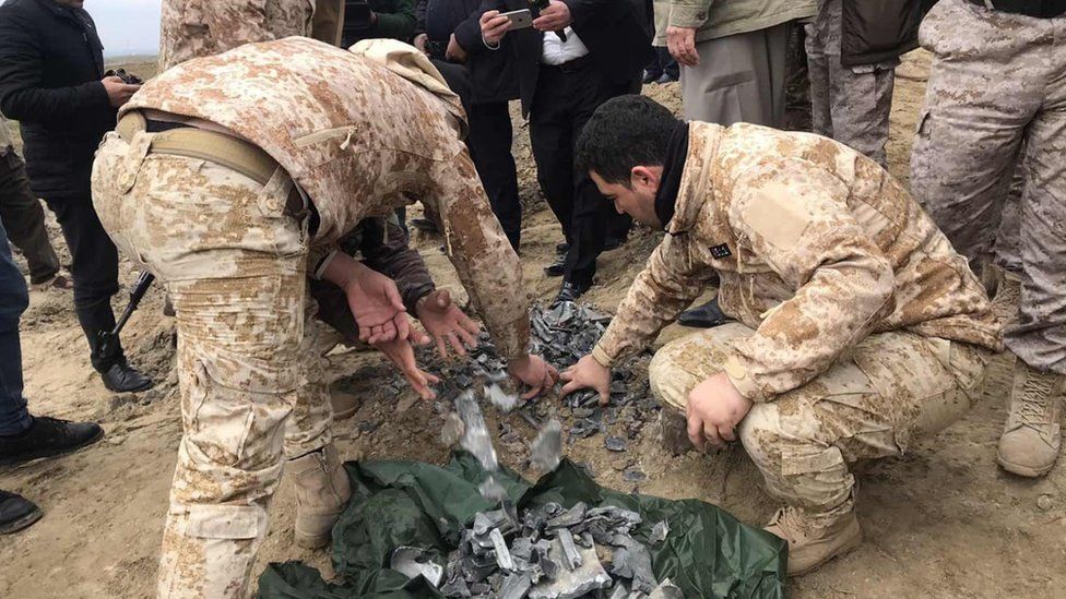 Iraqi security forces find and collect the pieces of missiles