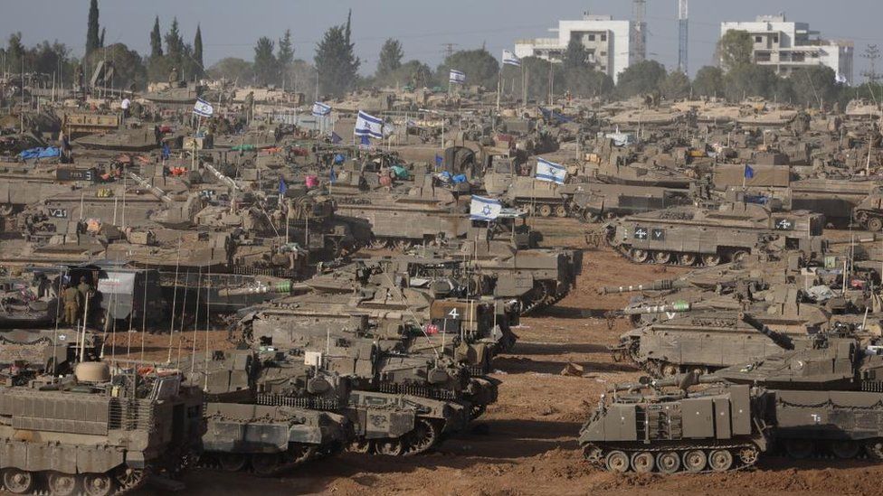 Israeli tanks and other armoured vehicles gather near the Gaza border fence on 9 May 2024