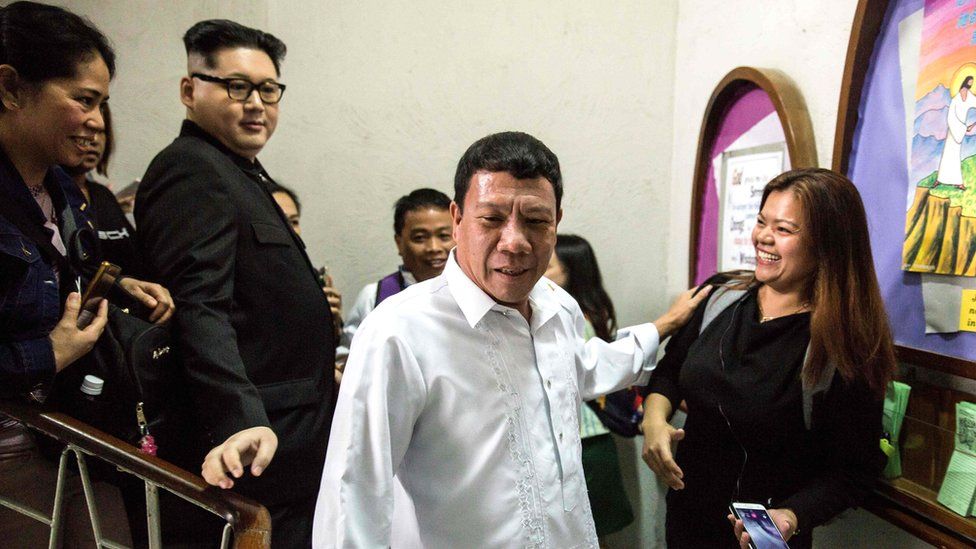 A Philippine President Rodrigo Duterte impersonator (C), who goes by the name Cresencio Extreme, and a North Korean leader Kim Jong-un impersonator, who goes by the name Howard X