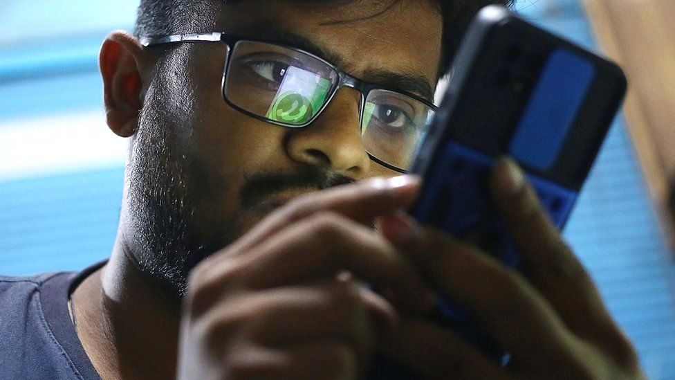 A man tries to use WhatsApp following the outage to services, in Karachi, Pakistan, 4 October 2021