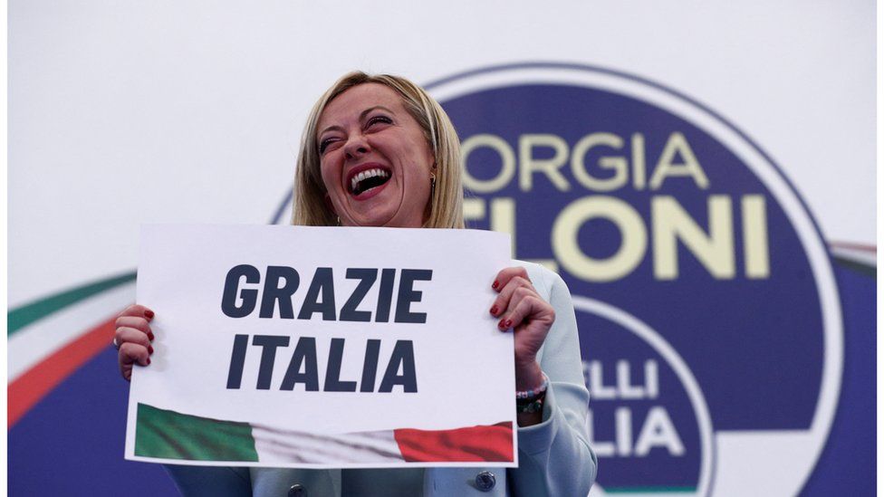 Leader of Brothers of Italy Giorgia Meloni holds a sign at the party's election night headquarters
