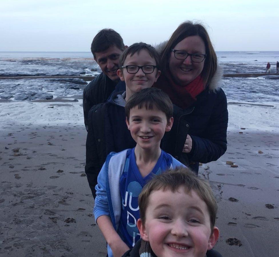 Selfie of Emma Laughton with her husband and three boys on a beach