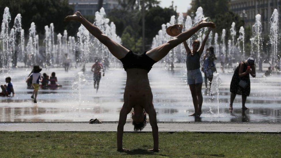 A man does a handstand in the French city of Nice - 27 June
