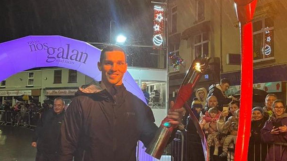 George North holding a torch