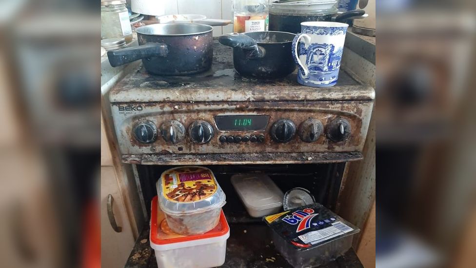 A dirty hob with pots and pans