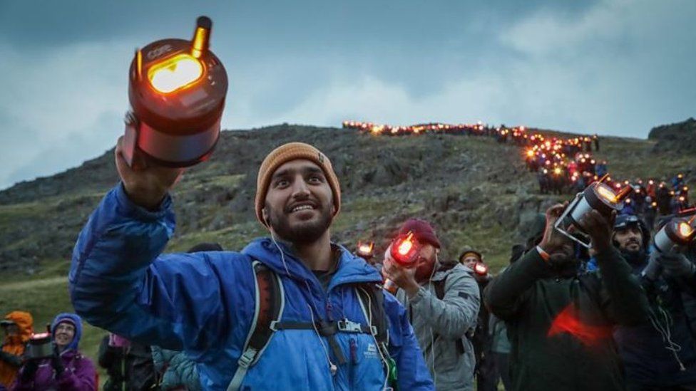 A trail of people holding lanterns on Scafell Pike