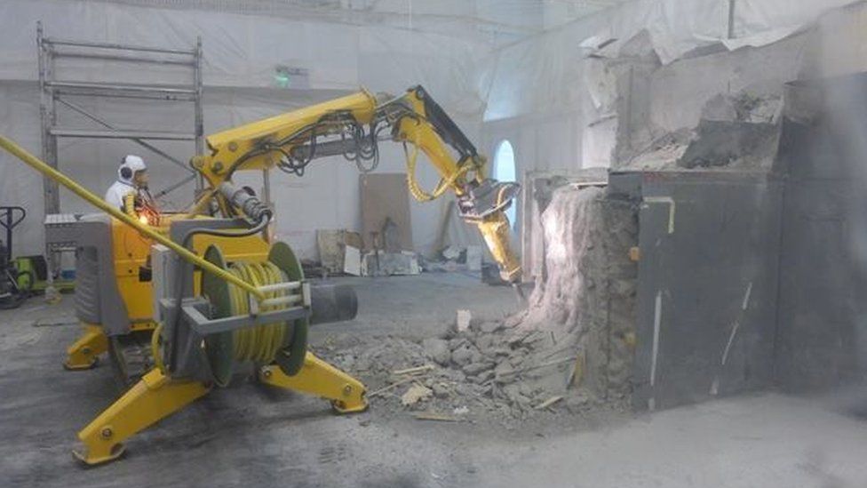 Robotic machine demolishing parts of the interior of a building at Dounreay