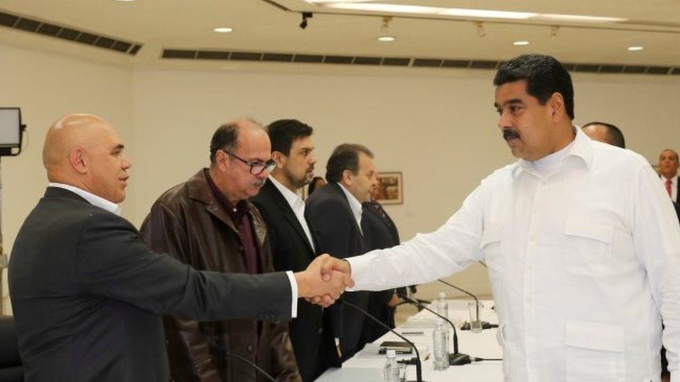 Venezuela's President Nicolas Maduro (R) shakes hands with Jesus Torrealba (L), secretary of Venezuela's coalition of opposition parties (MUD), during a political meeting between government and opposition, in Caracas, Venezuela October 30, 2016