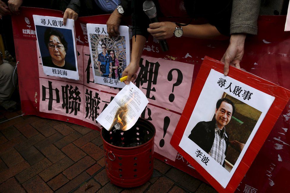 A pro-democracy demonstrator burns a letter next to pictures of missing staff members of a publishing house and a bookstore, including Gui Minhai, a China-born Swedish national who is the owner of Mighty Current, Cheung Jiping, the business manager of the publishing house and Causeway Bay Books shareholder Lee Bo (L-R), during a protest to call for an investigation behind their disappearance, outside the Chinese liaison office in Hong Kong, China 3 January 2016