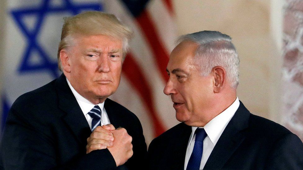 President Trump and PM Netanyahu shake hands in front of Israeli and US flags