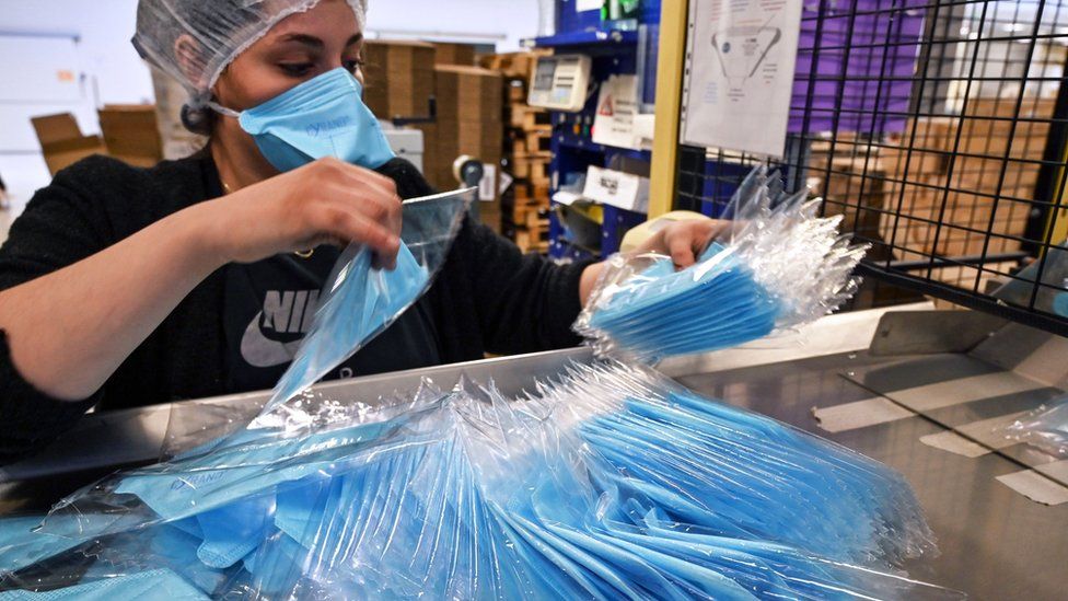An employee packs protective face masks