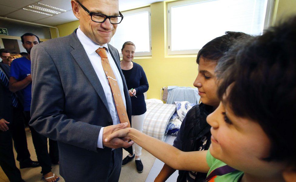Finland's Prime Minister Juha Sipila (L) visits a reception centre for asylum seekers in Oulu, northern Finland, on September 5, 2015.