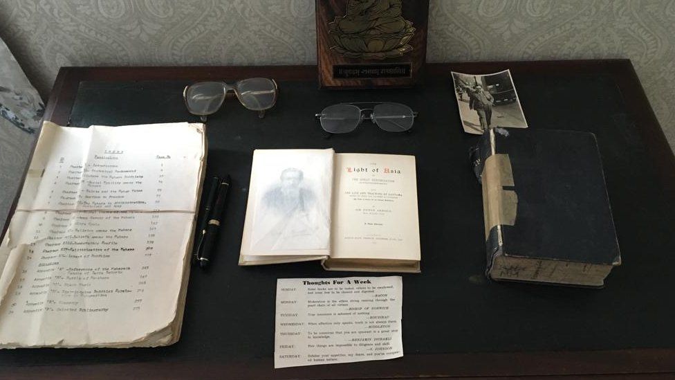 A desk with replica books and a pair of glasses