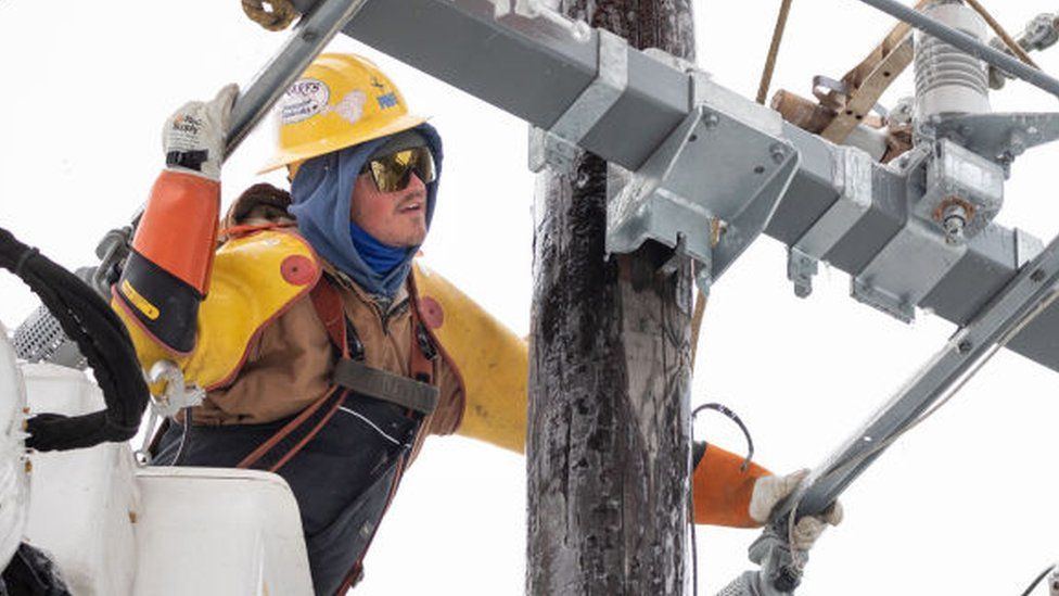 An electricity worker fixing a damaged power line in Texas