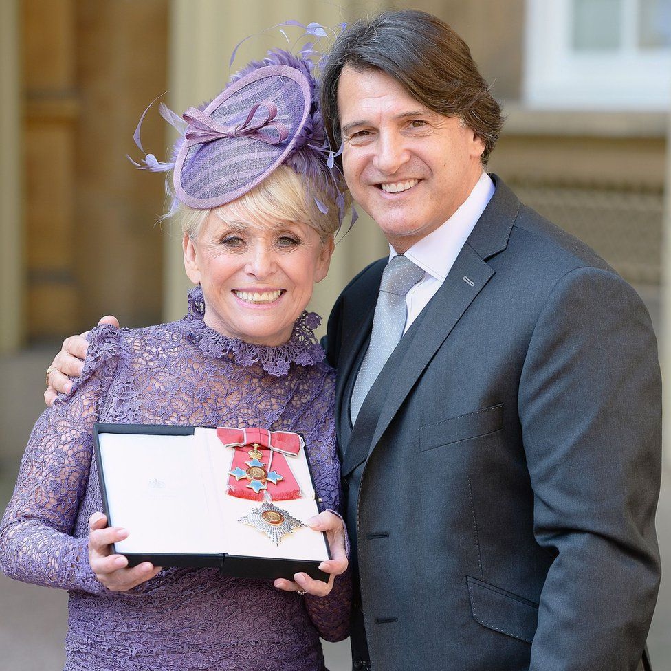 Third husband Scott Mitchell accompanied Windsor when she was made a dame at Buckingham Palace in 2016