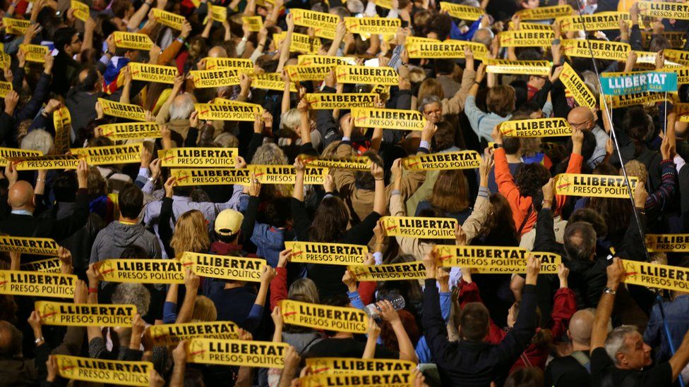 People hold banners reading "Freedom Political Prisoners" during a gathering in support of the members of the dismissed Catalan cabinet after a Spanish judge ordered the former Catalan leaders to be remanded in custody pending an investigation into Catalonia"s independence push, outside Barcelona"s town hall, Spain, November 3, 2017