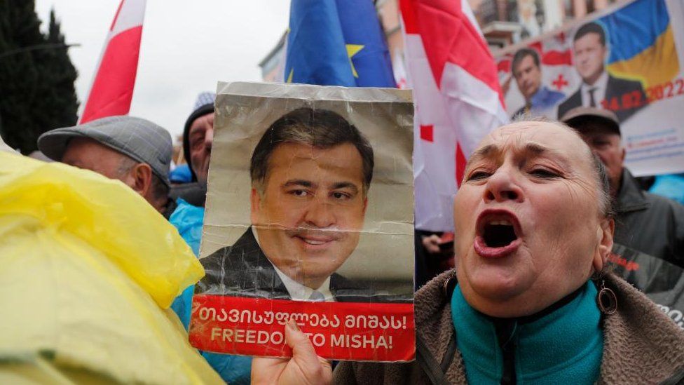 Демонстрант выкрикивает лозунги, держа портрет бывшего президента Грузии Михаила Саакашвили во время митинга с призывом к его освобождению из тюрьмы, в Тбилиси, Грузия, 3 декабря 2022 г.