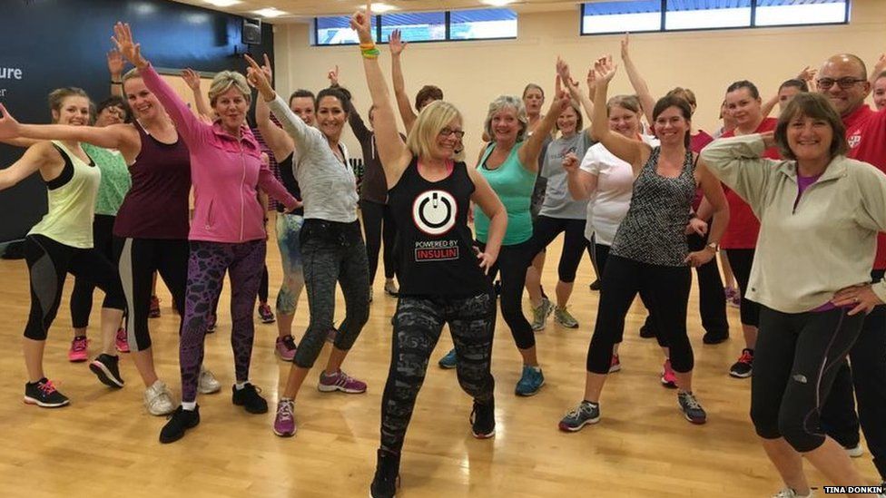 Fitness instructor Tina Donkin posing with her Zumba class