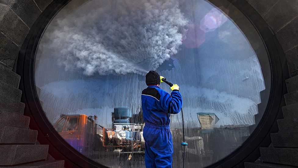 A worker disinfects a window in Prague, Czechia - 1 April 2020