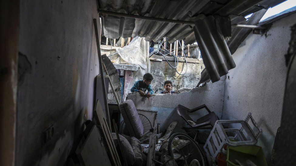 Two children collect belongings from a destroyed home in Rafah, southern Gaza on 1 April