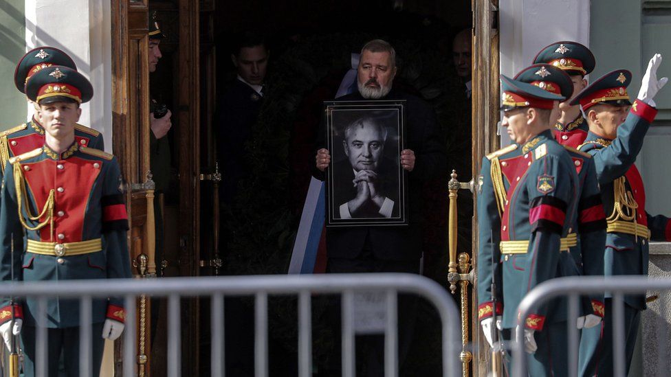 Dmitry Muratov carrega retrato de Gorbachev enquanto ele leva o caixão para fora após a mentira no estado