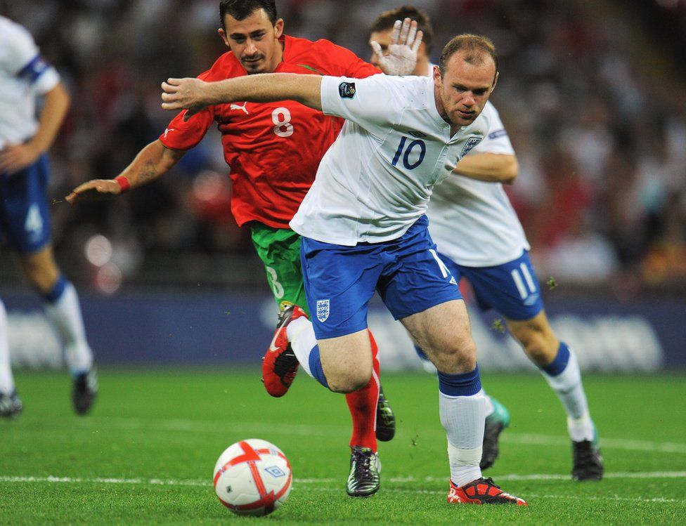 Wayne Rooney (right) of England holds off the challenge of Chavdar Yankov of Bulgaria at Wembley in September 2010